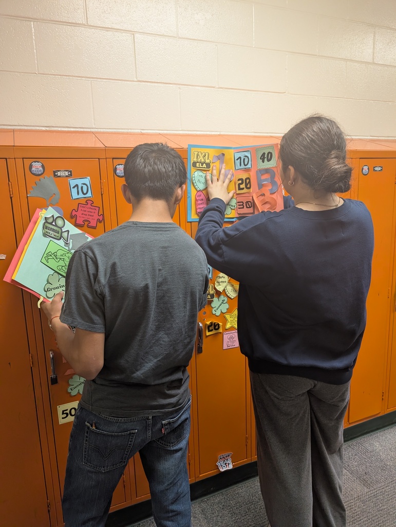 Student taking locker swag off of their lockers and putting it in their memory books.