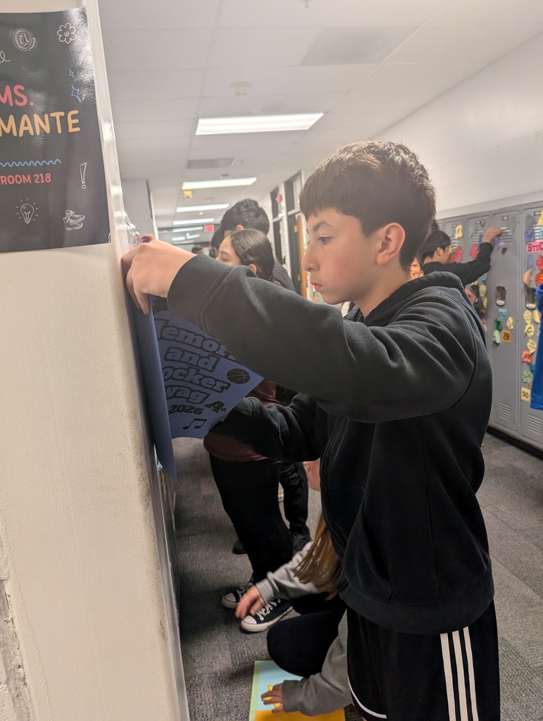 Student taking locker swag off of their lockers and putting it in their memory books.