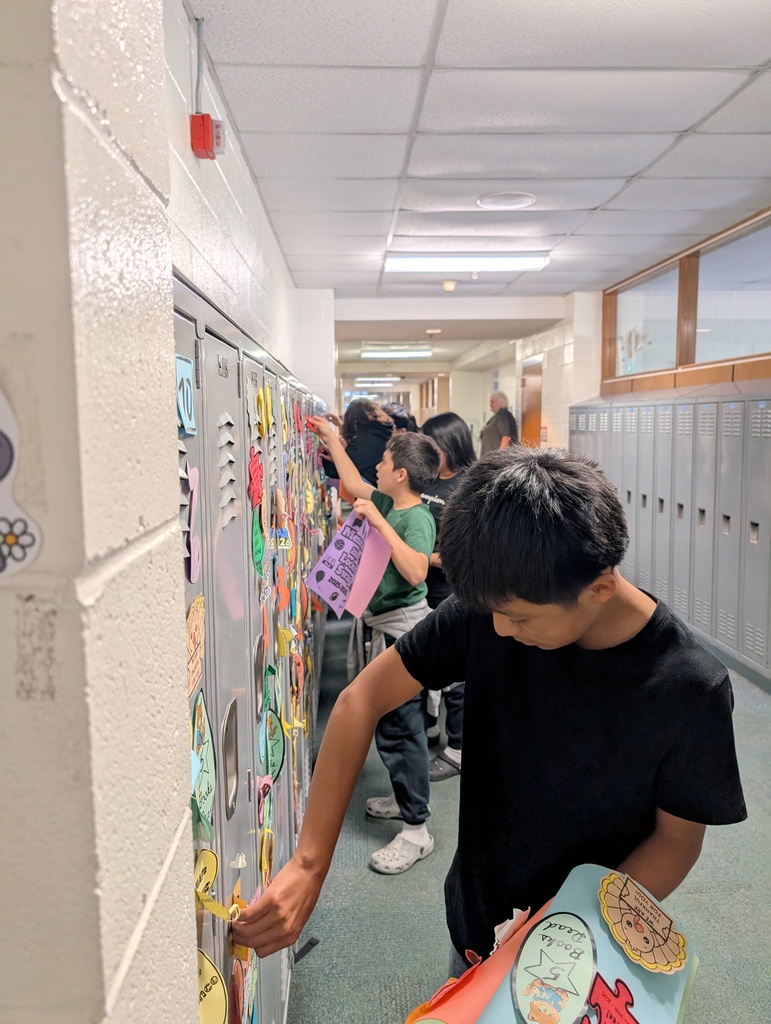 Student taking locker swag off of their lockers and putting it in their memory books.