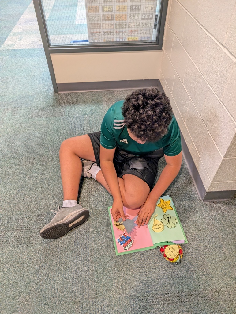 Student taking locker swag off of their lockers and putting it in their memory books.