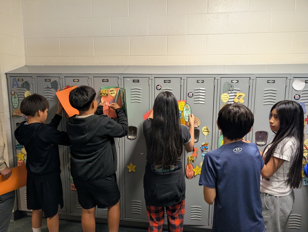 Student taking locker swag off of their lockers and putting it in their memory books.