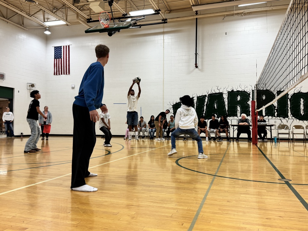 student hitting the volleyball during staff vs. student volleyball game