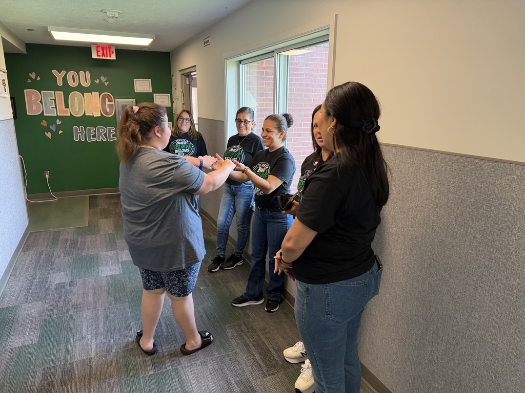 Staff members welcoming students.