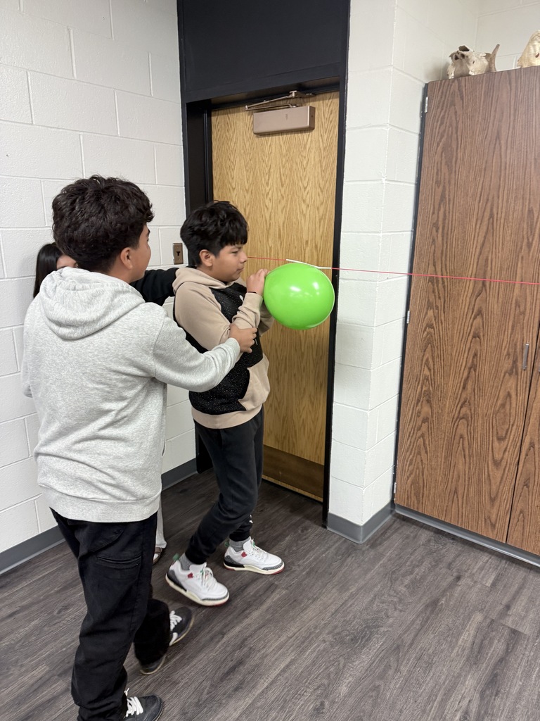 Students work together on a hands-on activity involving a balloon, demonstrating teamwork, coordination, and problem-solving.