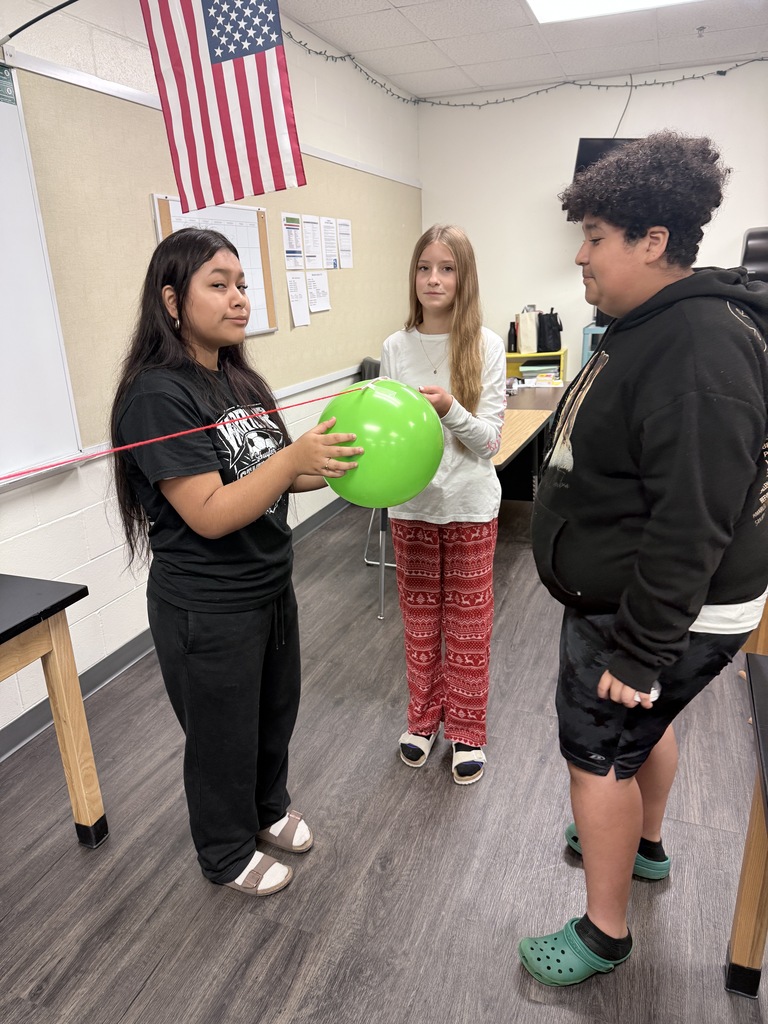 Students are participating in a hands-on balloon activity, working together and practicing teamwork and communication.