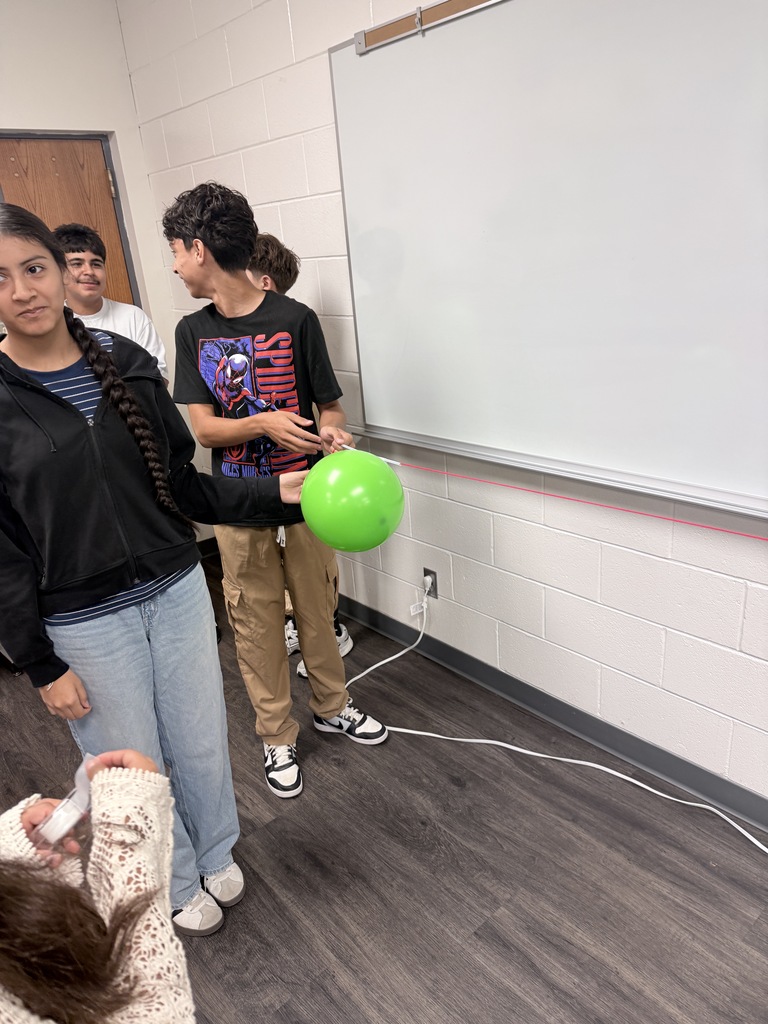 Students are participating in a hands-on balloon activity, working together and practicing teamwork and coordination.