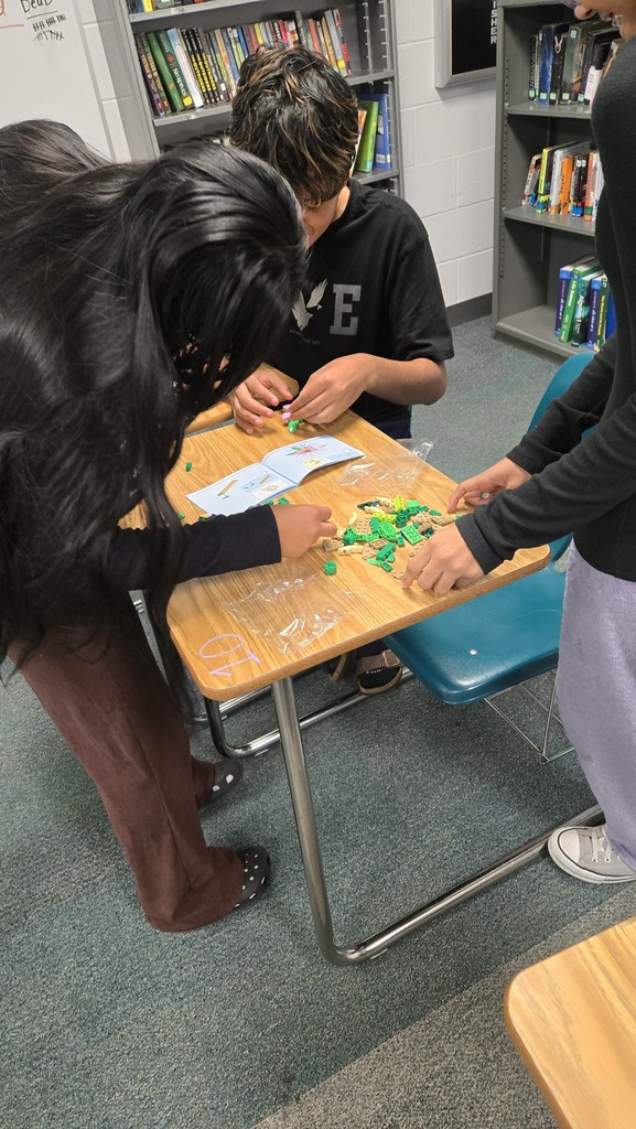 three students putting together legos