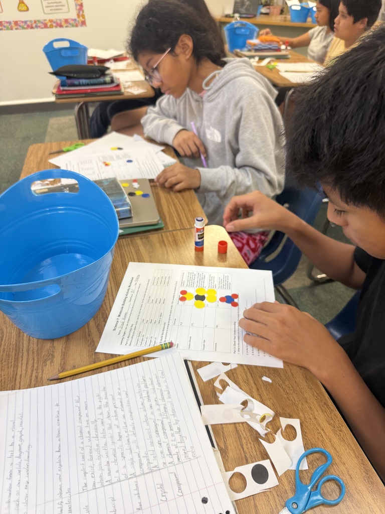 students using paper atom models to build simple molecules