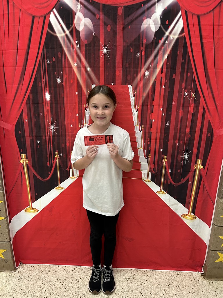 Smiling girl standing in front of a red backdrop