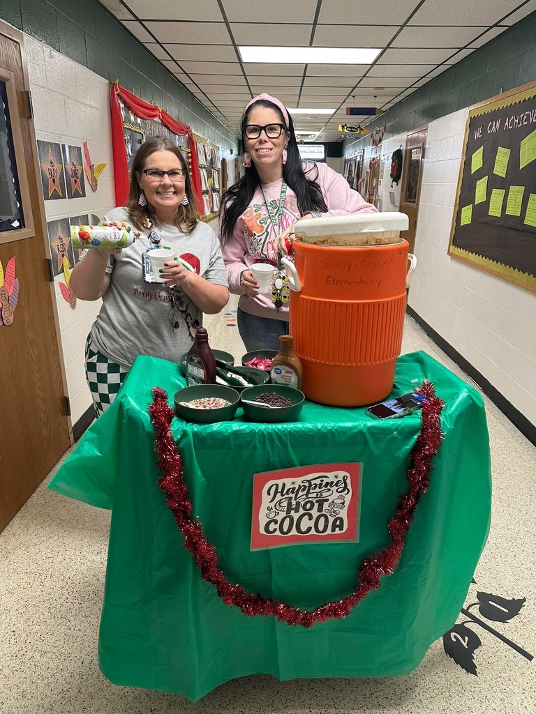 Two cheerful ladies serving hot cocoa from a rolling cart