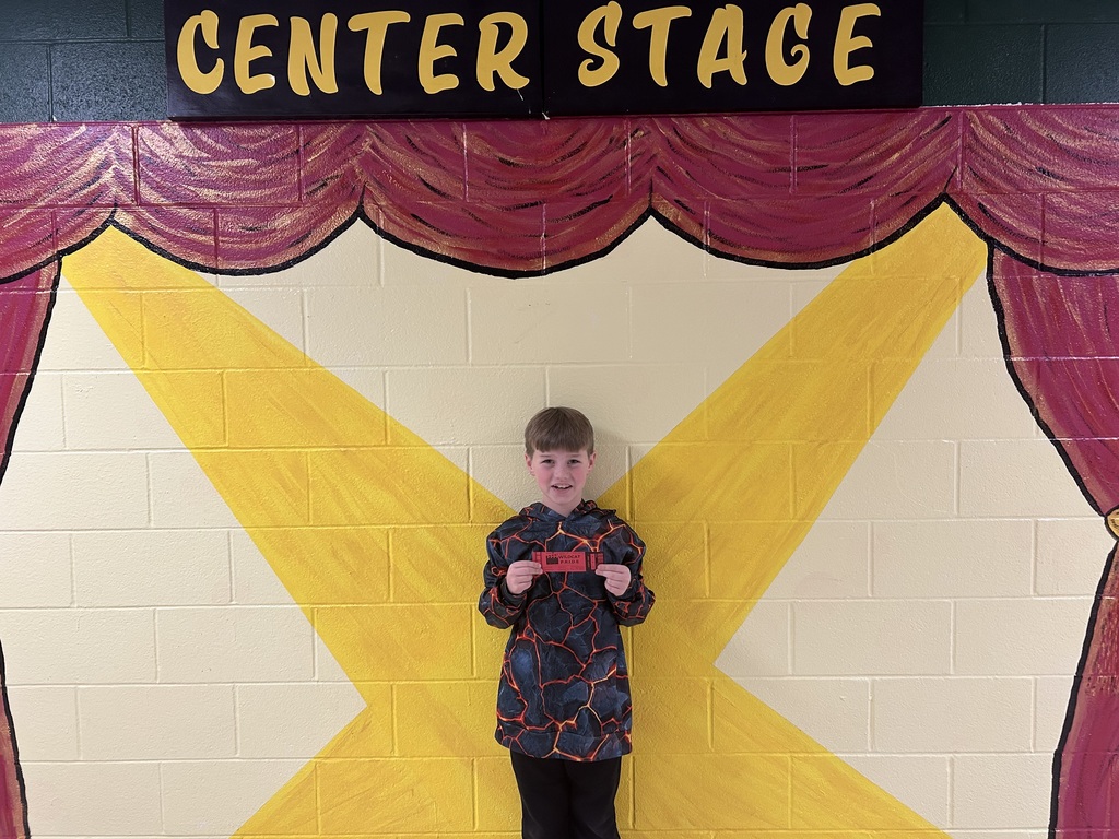smiling boy holding  a wildcat pride ticket
