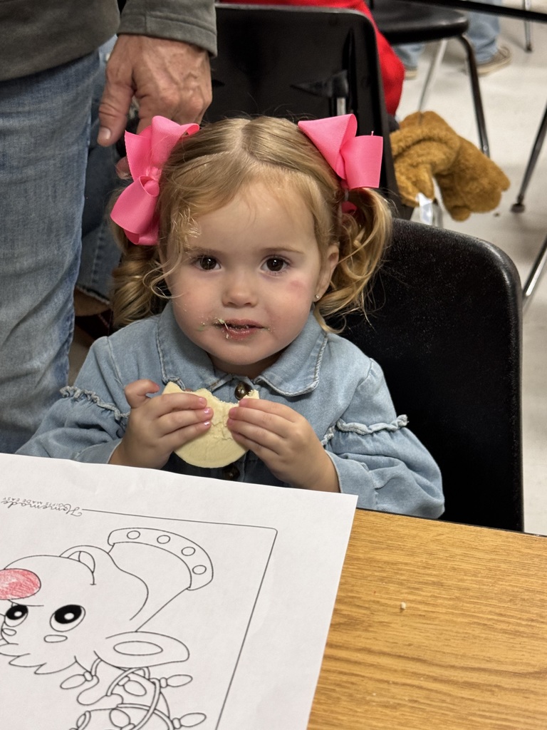 young girl with pig tails eating a cookie
