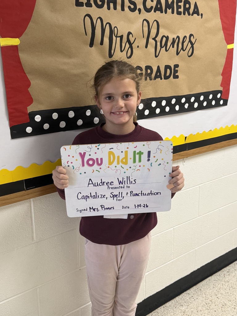 Smiling child holding a celebratory whiteboard