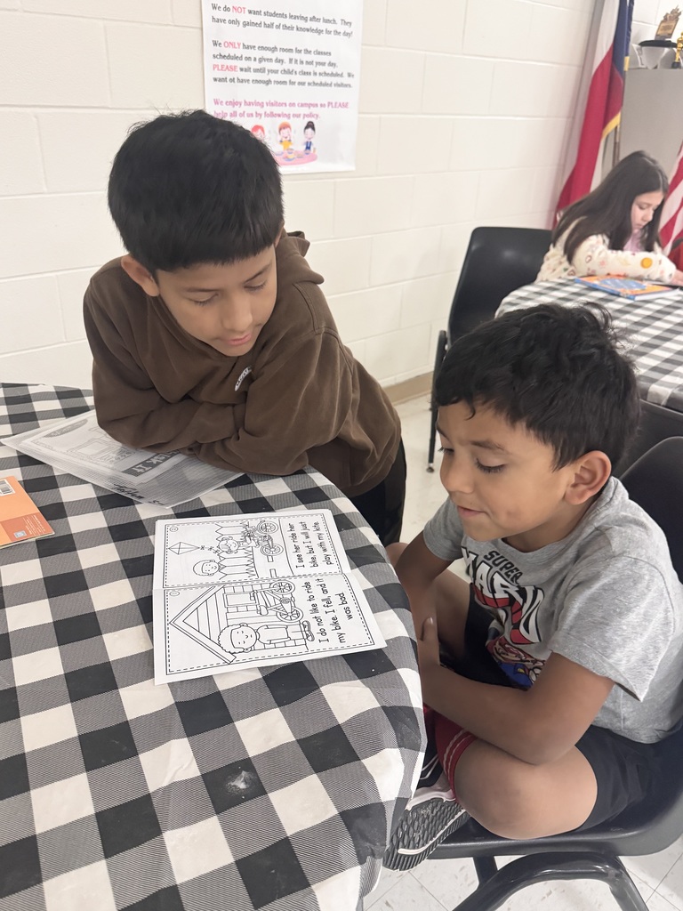 second and third graders reading to first grade students