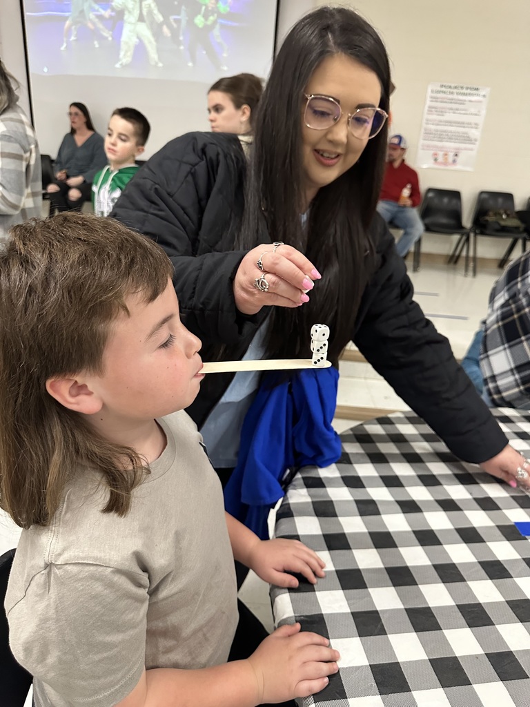 game image of adult female stacking dice on a tongue depresser in a child's mouth