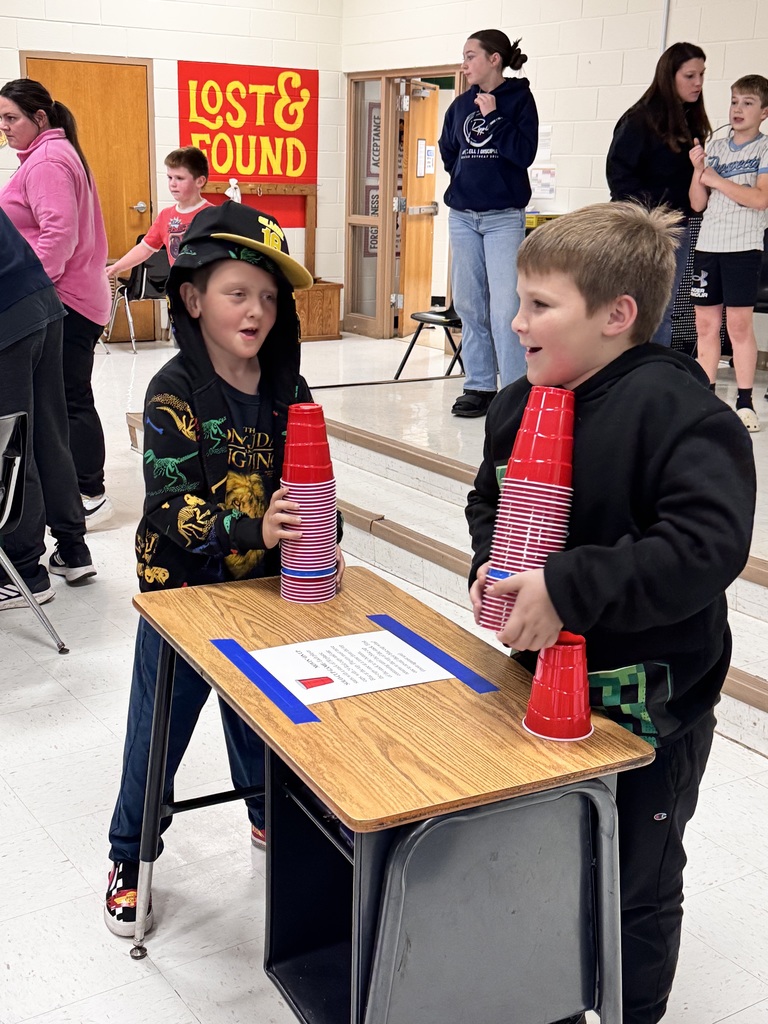 two elementary aged students stacking cups