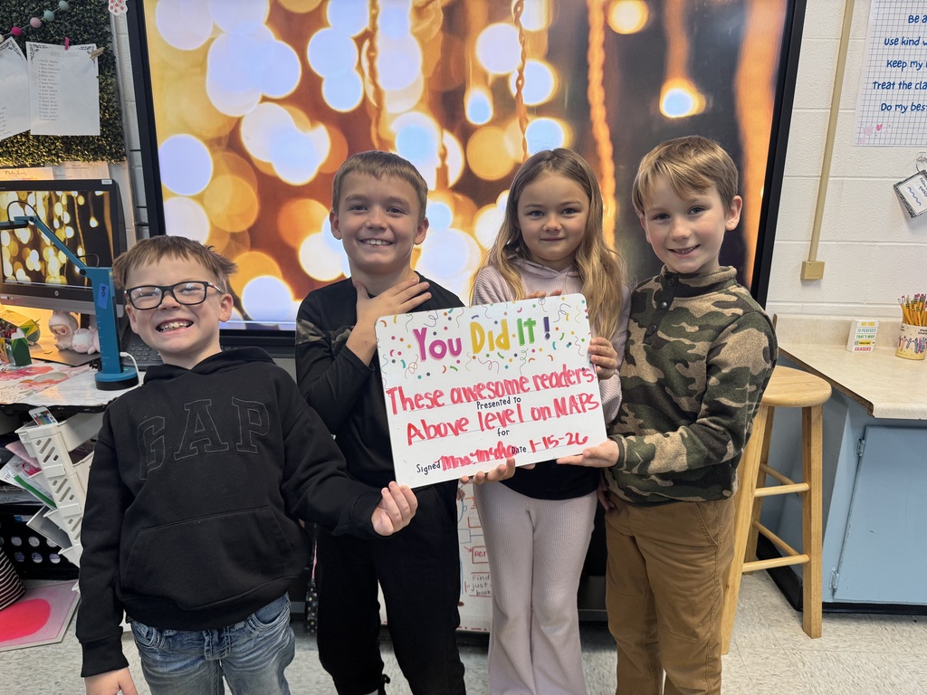 group of happy students holding a sign