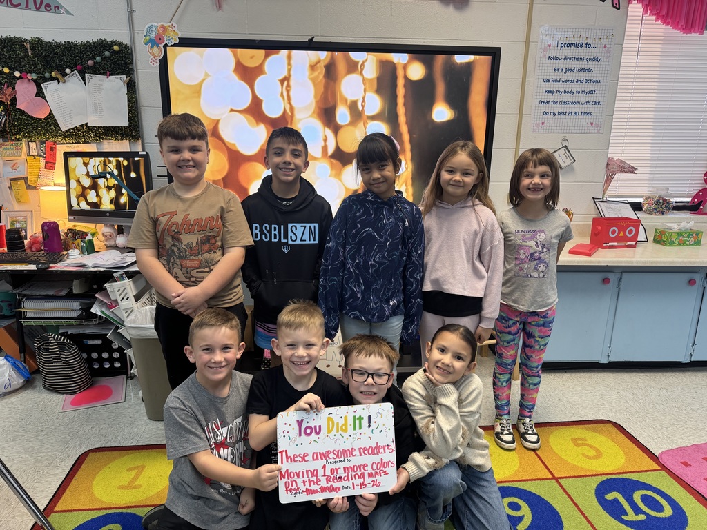 group of happy students holding a sign