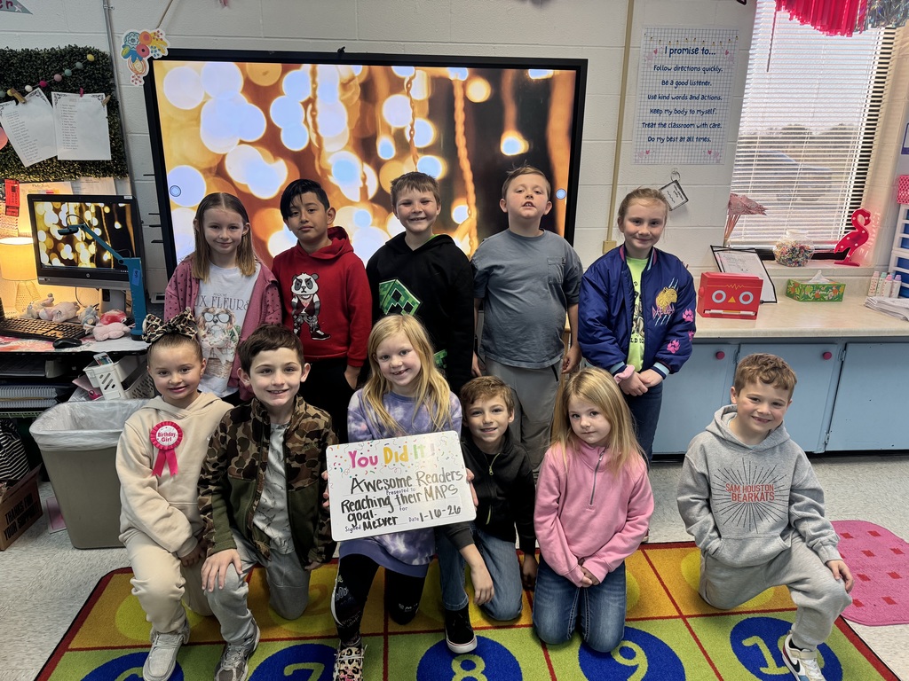 group of happy students holding a sign