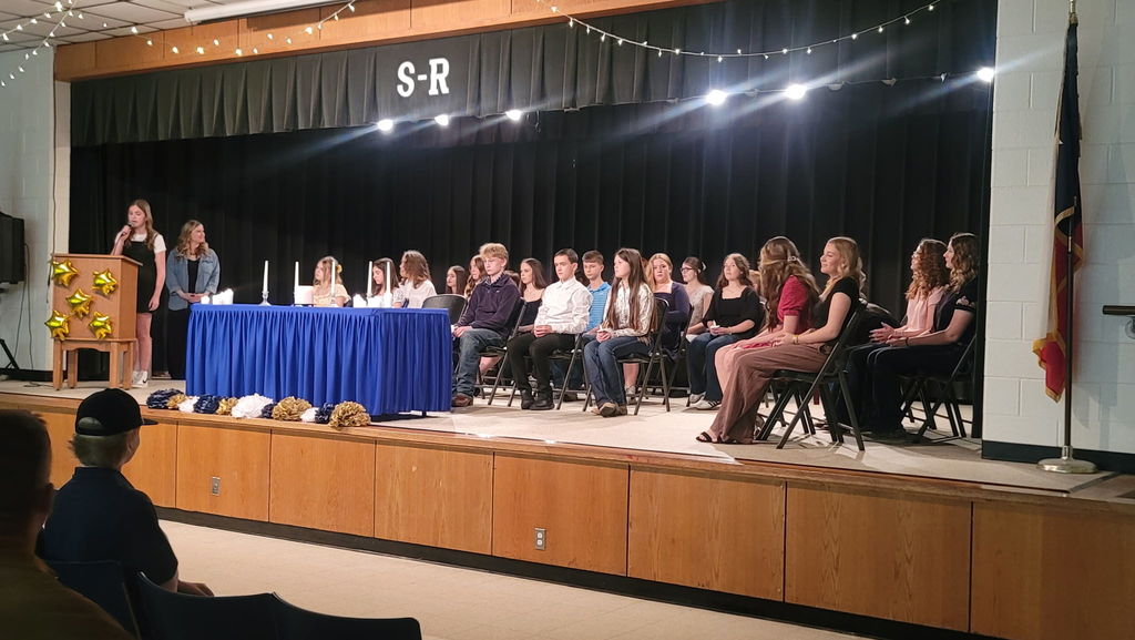 Group of students seating on stage