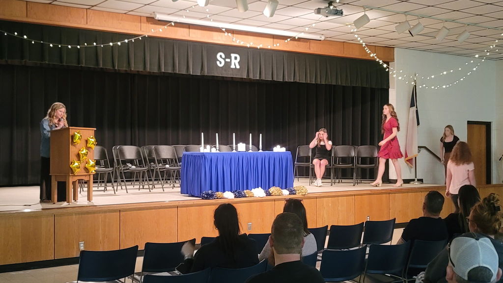 Teacher speaking to the audince on stage