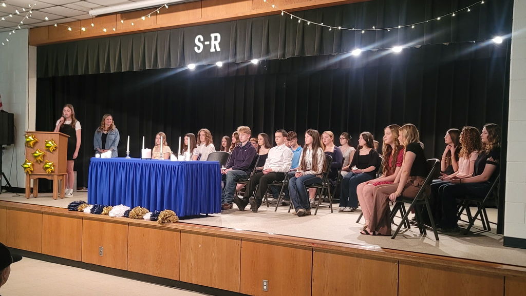 Group of students seating on stage