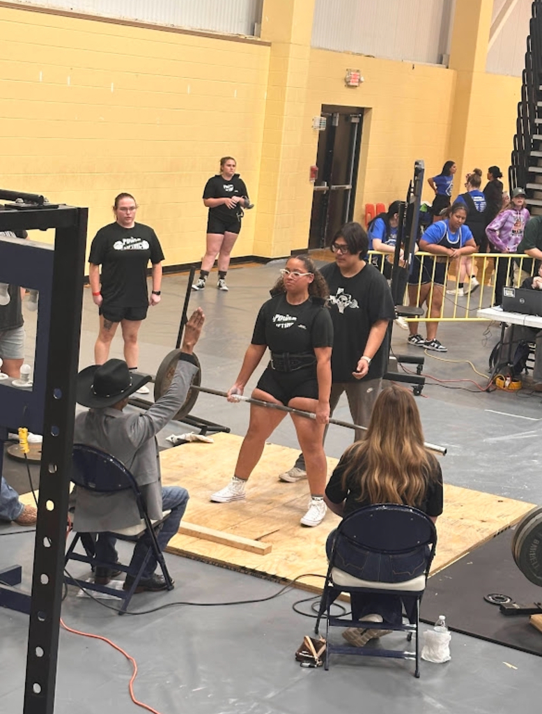 girl lifting barbell with weights with man judging her and a teenage boy spotting her