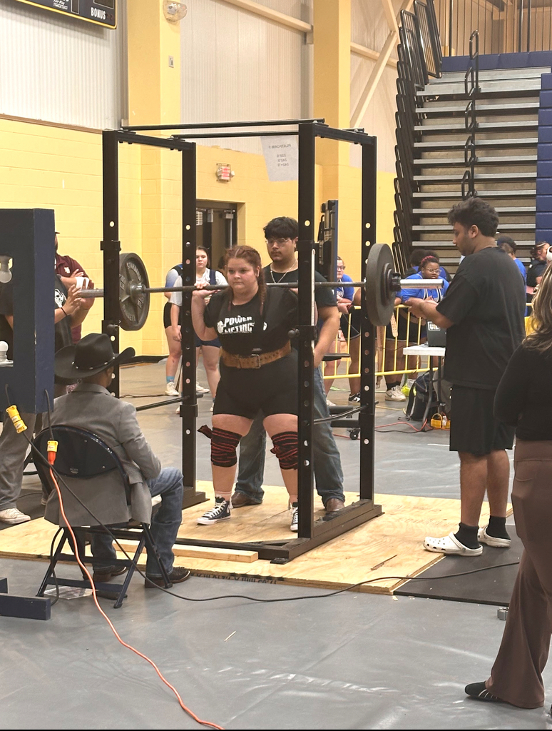 girl lifting barbell with weights with man judging her and a teenage boy spotting her