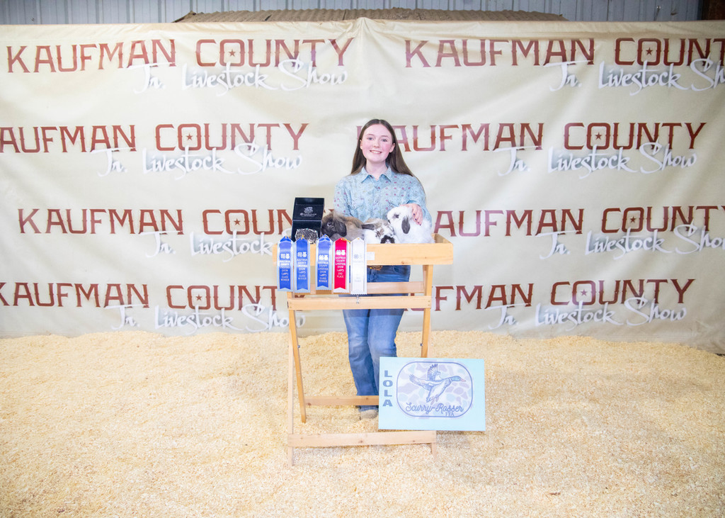 high school aged girl posing with her winning rabbits