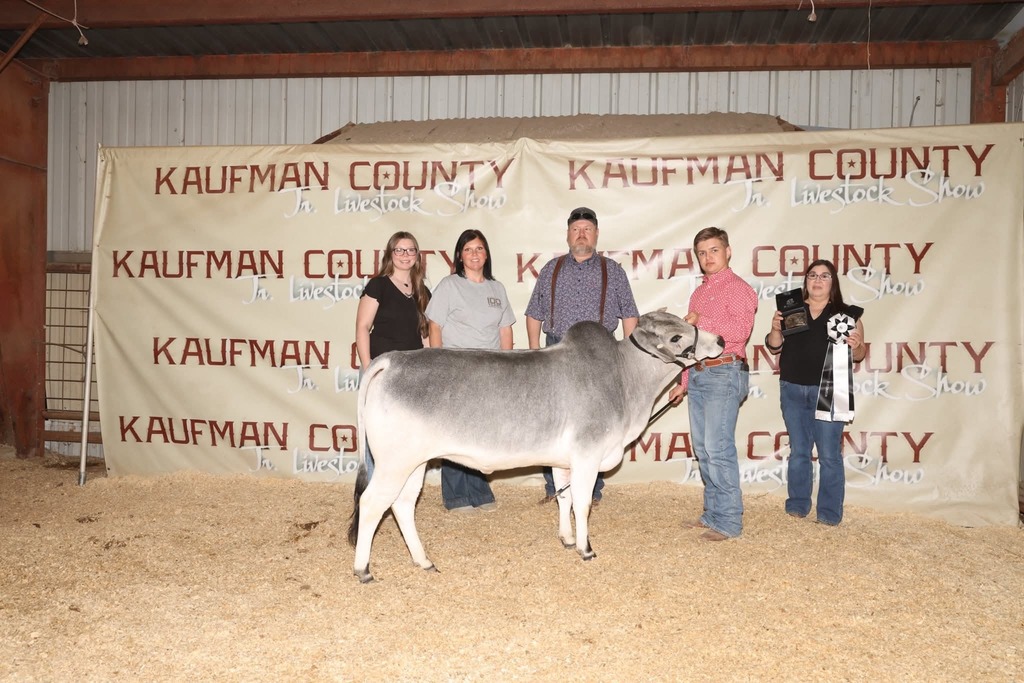 student and family posting with steer