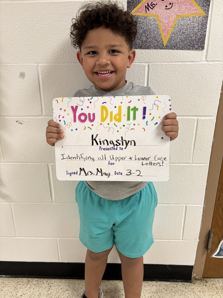 Smiling child holding celebration board