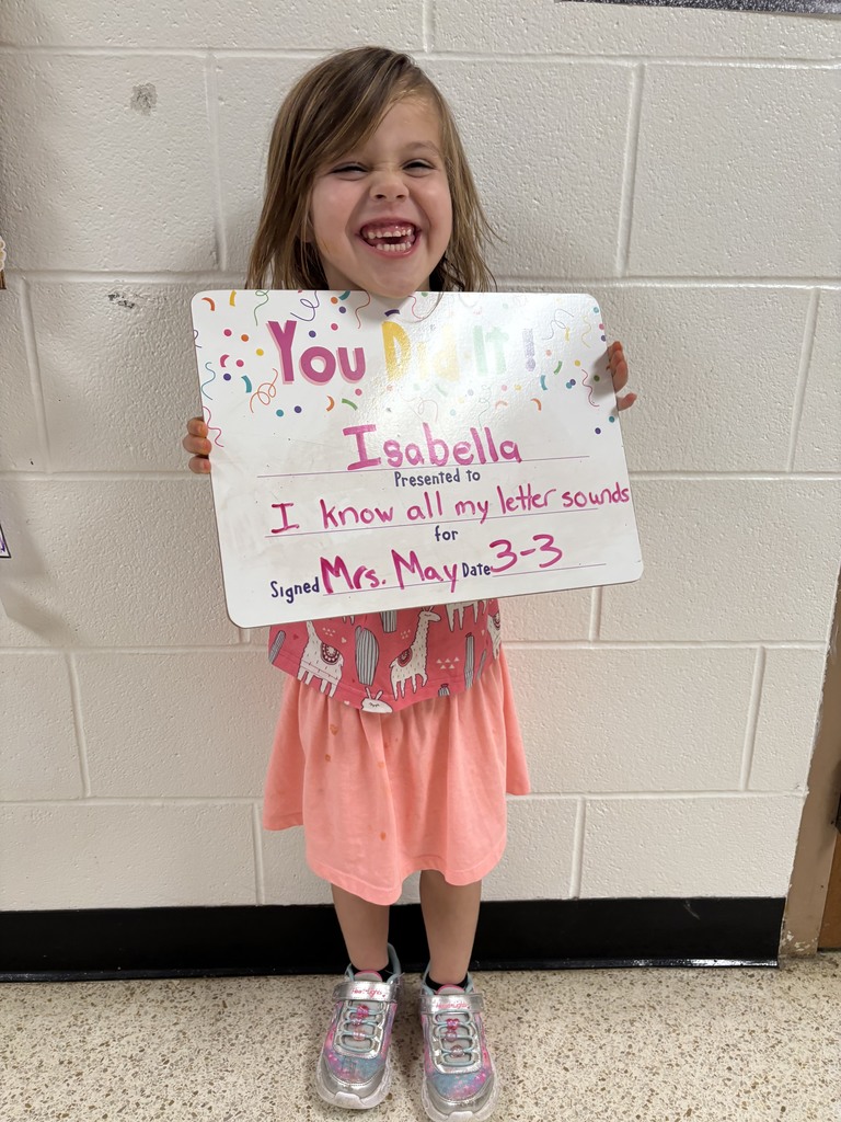 smiling child holding a celebration board