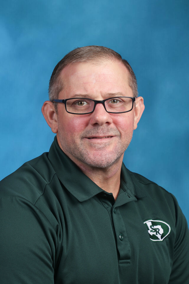 picture of a man in a green polo shirt wearing black glasses