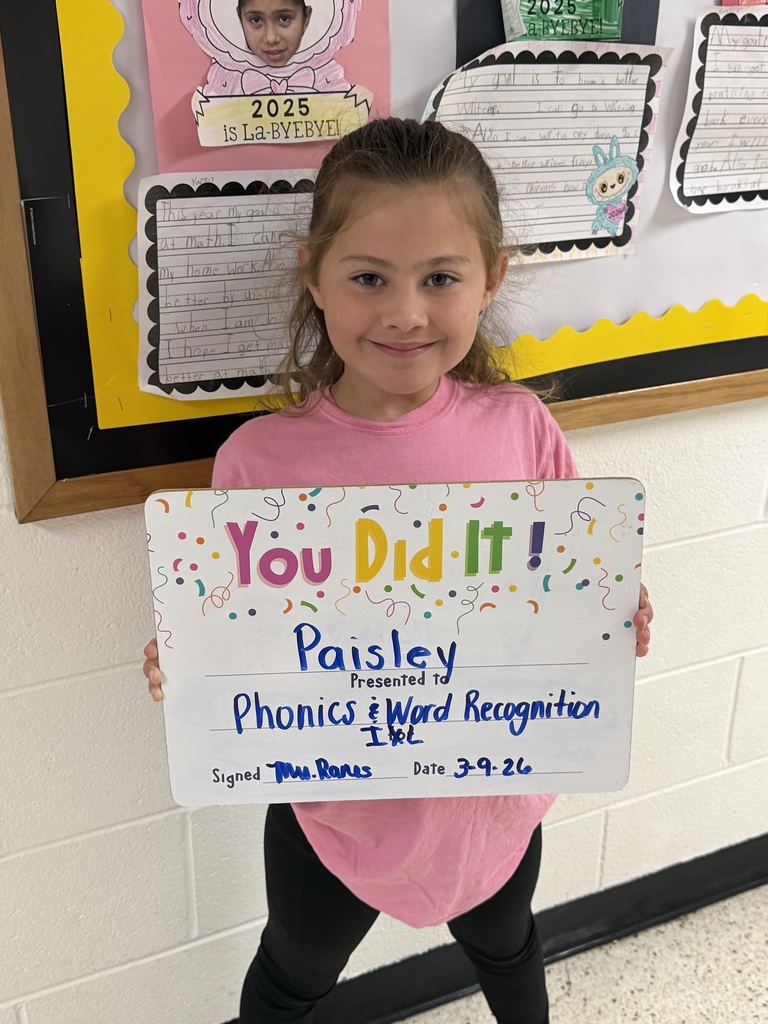 smiling child holding accomplishment board