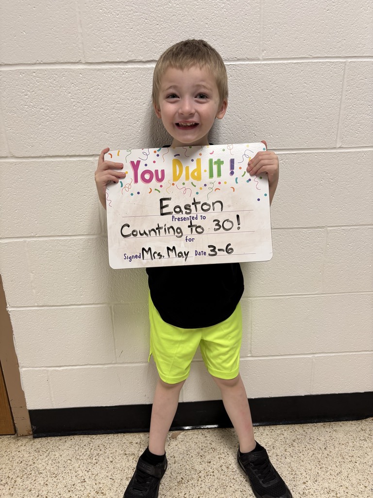 smiling child holding accomplishment board