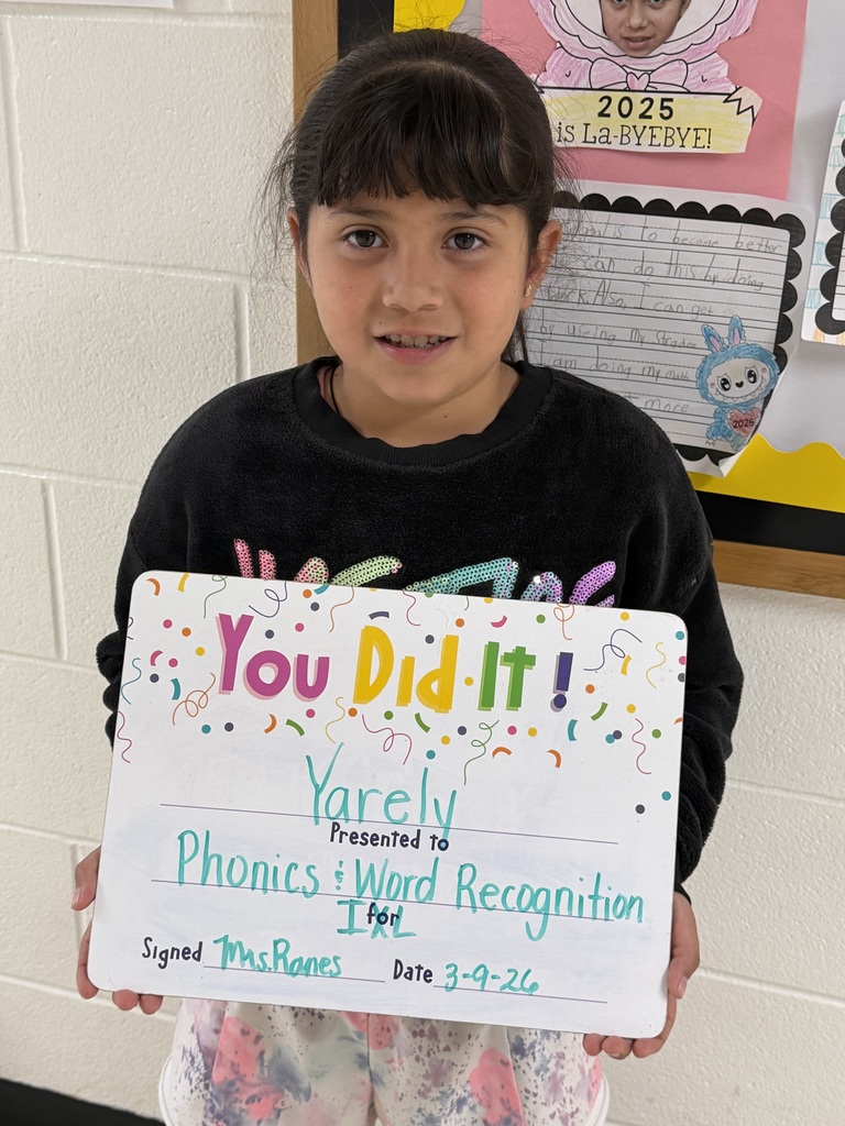 smiling child holding accomplishment board