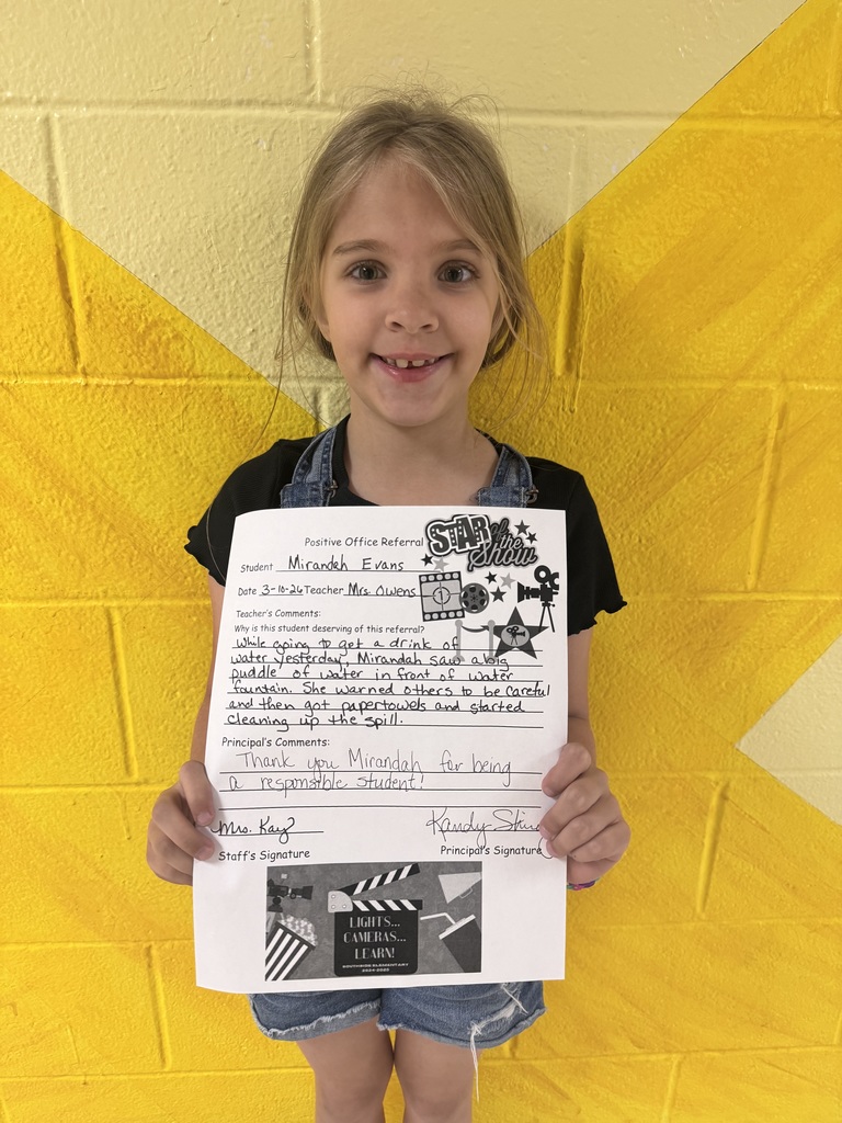 smiling child holding a piece of paper