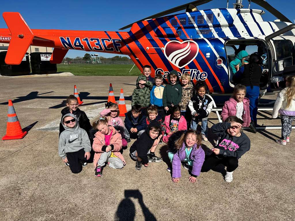 students standing in front of an emergency helicopter
