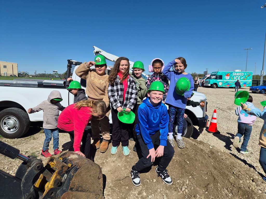 students standing on a dirt mound
