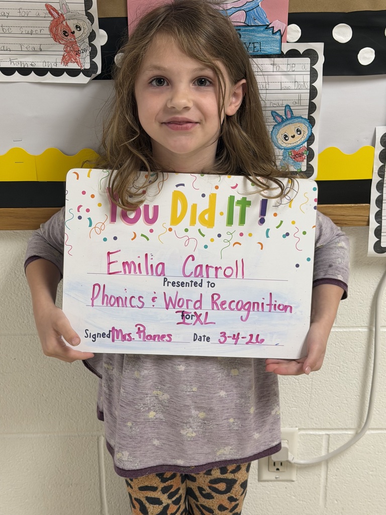 Smiling child holding a celebration board