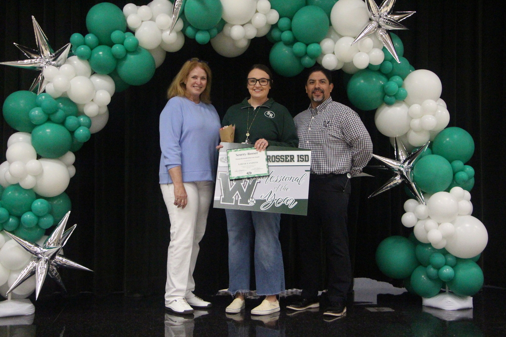 picture of two women and one man standing under a green and white balloon arch