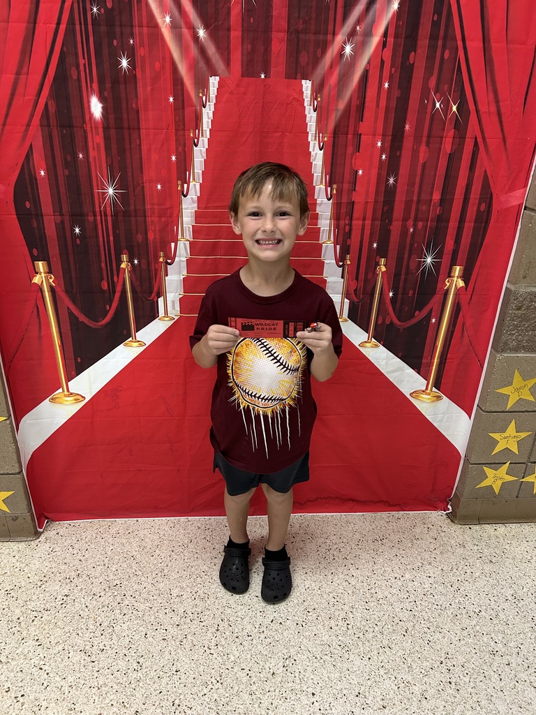 child holding recognition award