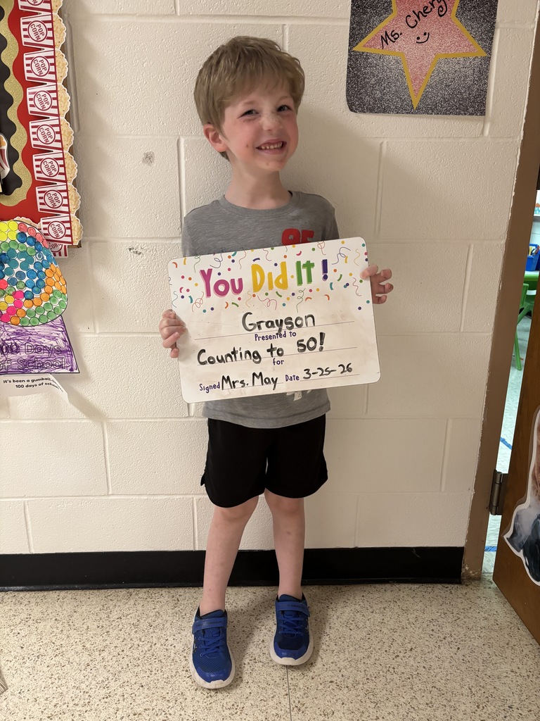 Child holding celebration board.