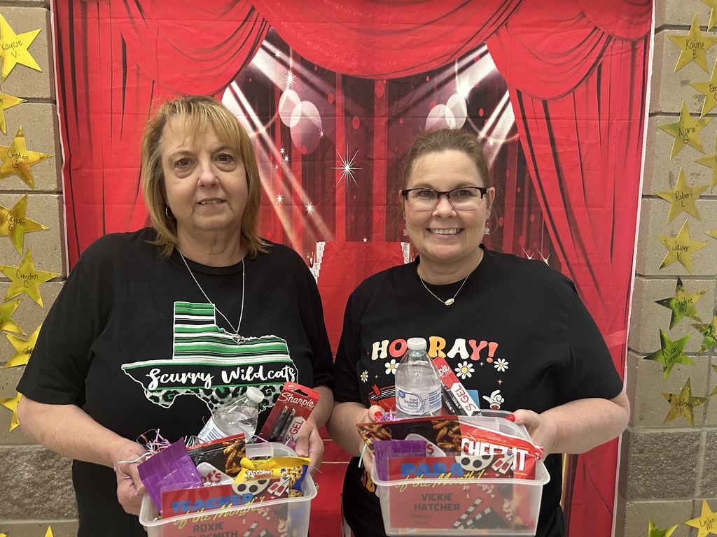 Two adult women, smiling, each holding a basket of goodies