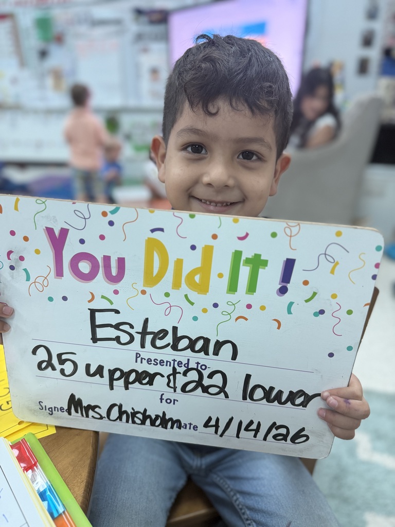Smiliing child holding a goal celebration board.