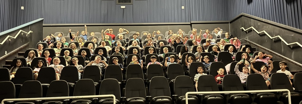 Large group of happy children at a movie theater.