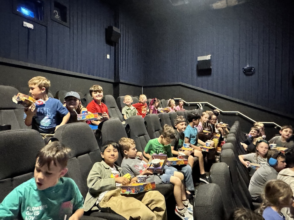 Large group of happy children at a movie theater.