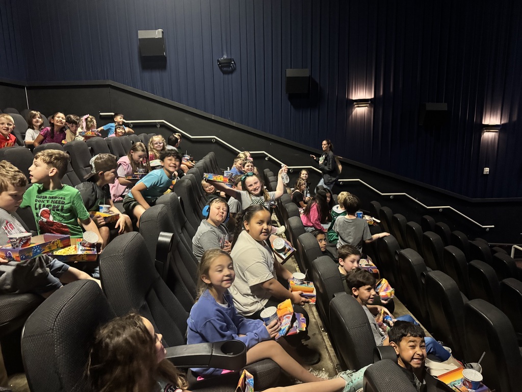 Large group of happy children at a movie theater.
