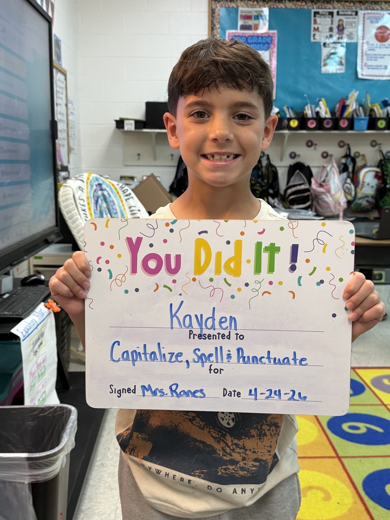 smiling child holding a celebration board