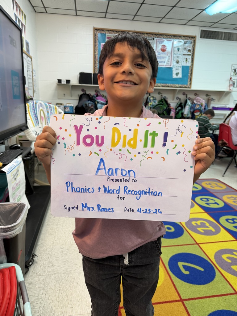 smiling child holding a celebration board